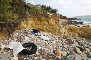 Çöp ve deniz kıyısında eski lastikler