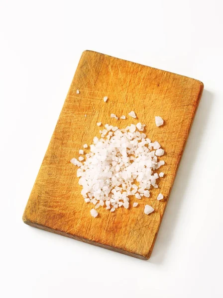 Coarse sea salt on cutting board — Stock Photo, Image