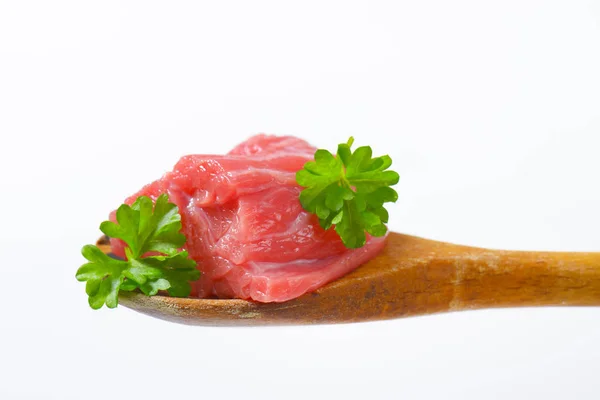 Pedazo de carne cruda en cuchara de madera —  Fotos de Stock