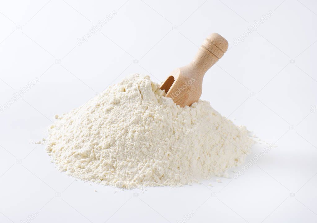 pile of wheat flour and scoop