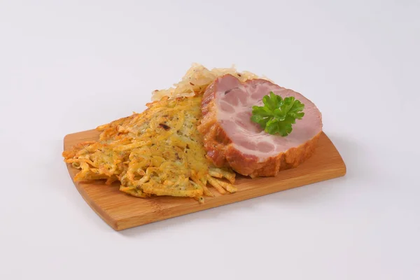 Geräuchertes Schweinefleisch mit Kartoffelpuffer und Sauerkraut — Stockfoto