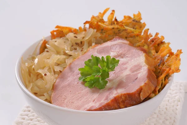 Gerookte varkensvlees met Aardappelpannenkoekjes en zuurkool — Stockfoto