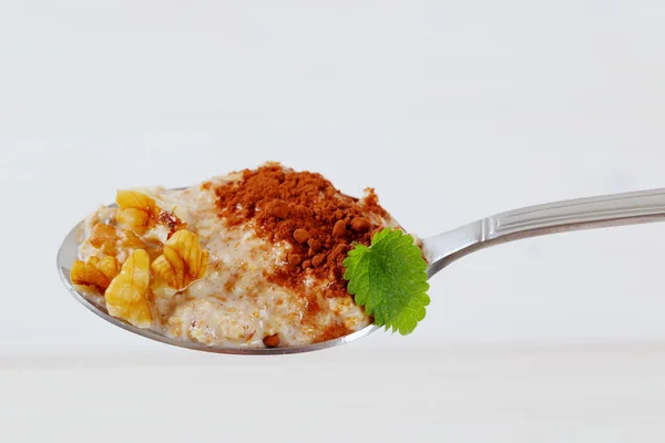 Cucharada de avena gachas con canela y nueces —  Fotos de Stock