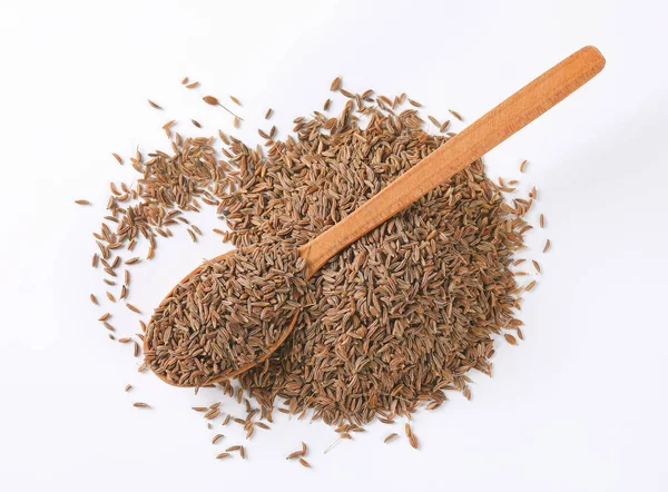 Pile et cuillère de graines de cumin — Photo