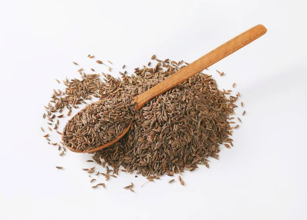 Pile et cuillère de graines de cumin — Photo