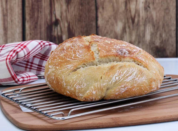 A loaf of fresh baked Artisan Bread on a cooling rack. — Stock Photo, Image