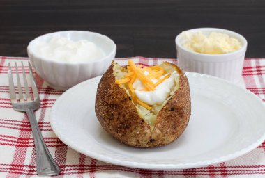 Ekşi krema ve dilimlenmiş çedar peyniri ile kaplanmış tuzlanmış patates..