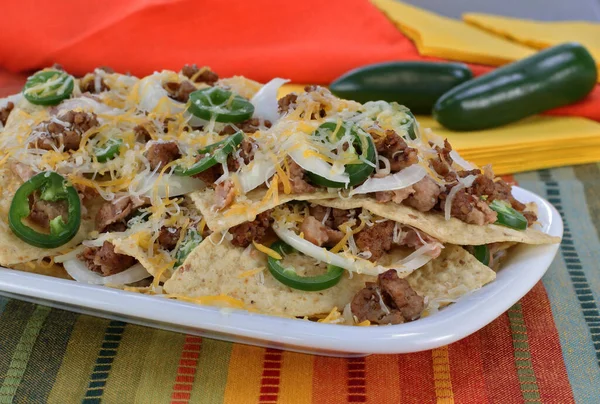楕円形のプレート上にメキシコのソーセージ 豆とチーズナチョス マクロを閉じる — ストック写真