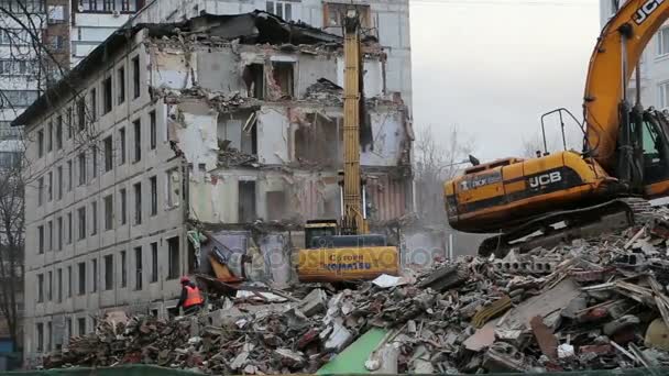 Екскаватор обладнання працює над знесення старий будинок. Москва, Російська Федерація — стокове відео