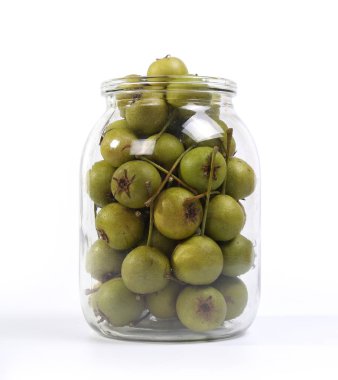 bir cam kavanoza doğal küçük yeşil armut beyaz arka plan üzerinde izole    