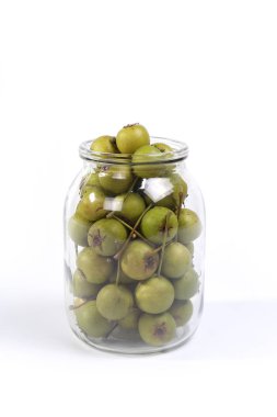 bir cam kavanoza doğal küçük yeşil armut beyaz arka plan üzerinde izole    