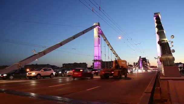 Krymsky Bridge of Krim Bridge en het verkeer van auto's (nacht)--is een stalen hangbrug in Moskou, Rusland. De brug overspant de Moskva rivier 1.800 meter ten zuidwesten van het Kremlin — Stockvideo