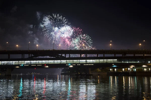 Fuochi d'artificio sul fiume Mosca Moskva, Luzhnetskaya Bridge (ponte della metropolitana) alla luce delle luci colorate notturne. Mosca, Russia — Foto Stock