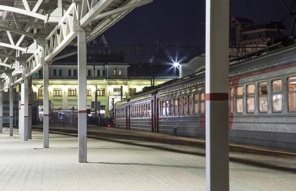 Train sur le quai des passagers de Moscou la nuit (gare Belorussky) -- est l'une des neuf principales gares ferroviaires de Moscou, en Russie. Il a été ouvert en 1870 et reconstruit dans sa forme actuelle en 1907-1912 — Photo