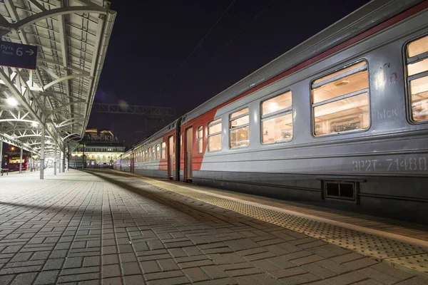 Train sur le quai des passagers de Moscou la nuit (gare Belorussky) -- est l'une des neuf principales gares ferroviaires de Moscou, en Russie. Il a été ouvert en 1870 et reconstruit dans sa forme actuelle en 1907-1912 — Photo