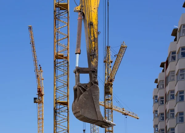 Elevando guindaste de construção contra o céu azul em um weat justo — Fotografia de Stock