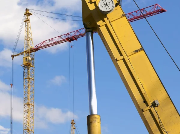 Elevación de la grúa de construcción contra el cielo azul en un weat justo — Foto de Stock