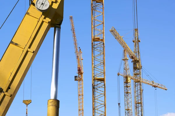 Elevando guindaste de construção contra o céu azul em um weat justo — Fotografia de Stock