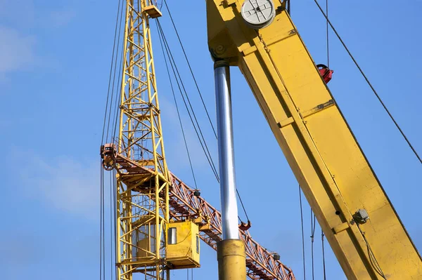 Elevating construction crane against the blue sky in a fair weat — Stock Photo, Image