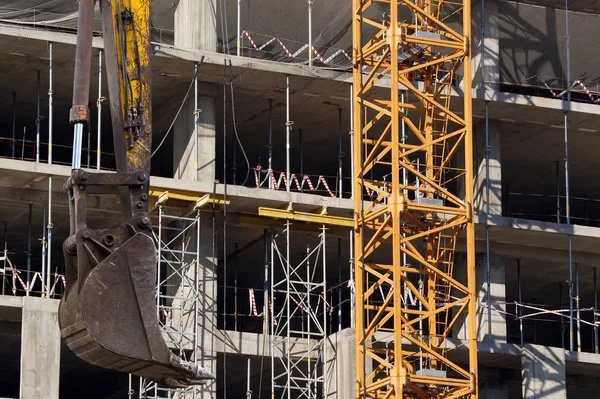 Grúa de construcción en el fondo de un edificio de varios pisos unde — Foto de Stock