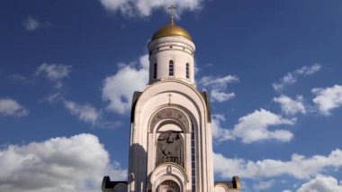 Poklonnaya tepesindeki Aziz George Kilisesi (hareket eden bulutların arka planında), Moskova, Rusya. İsa dirildi, Rusya 'daki büyük vatanseverlik yazıtında ölenlerin sonsuz anısı.   