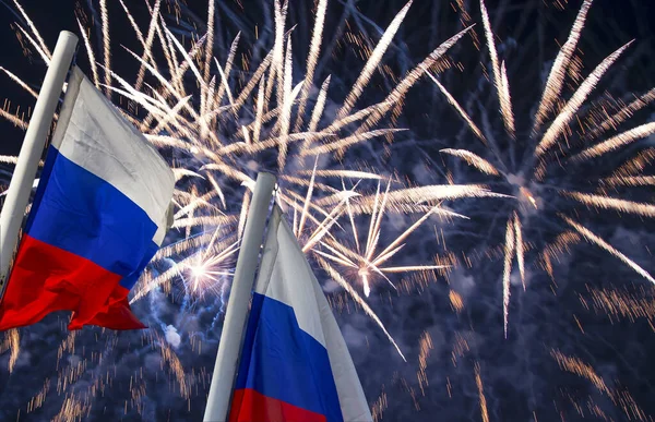 Russia flag waving in the wind and fireworks in honor of Victory Day celebration (WWII), Moscow, Russia. Three colors of Russian wavy flag as a patriotic symbol