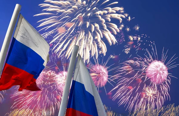 Russia flag waving in the wind and fireworks in honor of Victory Day celebration (WWII), Moscow, Russia. Three colors of Russian wavy flag as a patriotic symbol