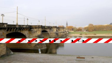 Dresden, Almanya 'da Coronavirus. Elbe nehri üzerindeki köprü manzarası. Bulanık arkaplanda Covid-19 işareti var. COVID salgını kavramı ve Avrupa 'da seyahat.