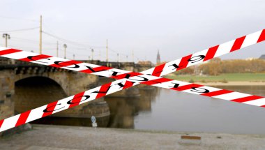 Dresden, Almanya 'da Coronavirus. Elbe nehri üzerindeki köprü manzarası. Bulanık arkaplanda Covid-19 işareti var. COVID salgını kavramı ve Avrupa 'da seyahat.