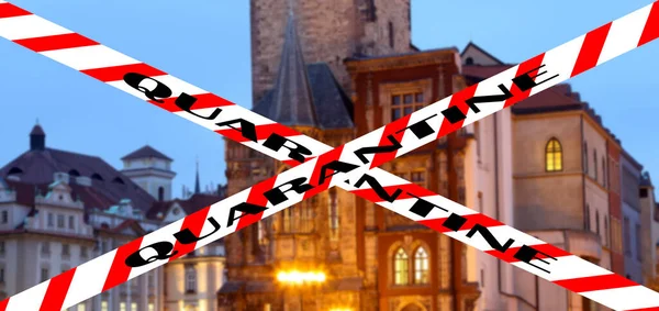 Coronavirus in Prague, Czech Republic. Old Town City Hall. Quarantine sign on a blurred background. Concept of COVID pandemic and travel in Europe.