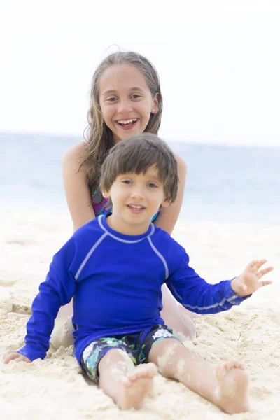 Szczęśliwa dziewczyna i chłopak gra na plaży — Zdjęcie stockowe