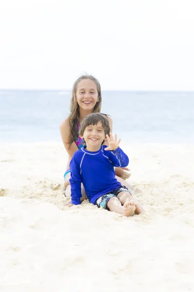 幸せな少女と少年がビーチで遊んで — ストック写真