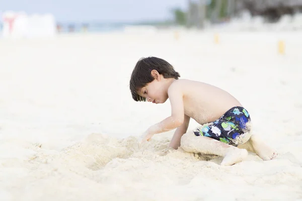 Szczęśliwy chłopiec gra na plaży — Zdjęcie stockowe