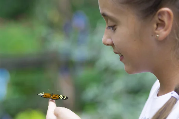 Menina feliz segurando uma borboleta — Fotografia de Stock