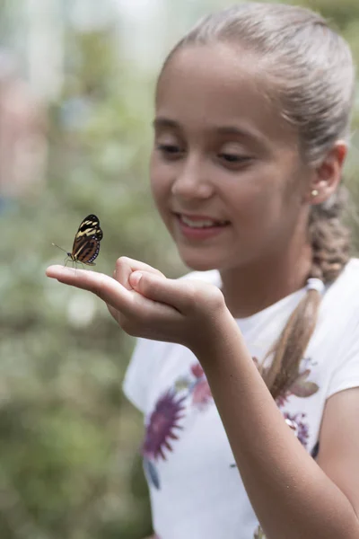 Menina feliz segurando uma borboleta — Fotografia de Stock