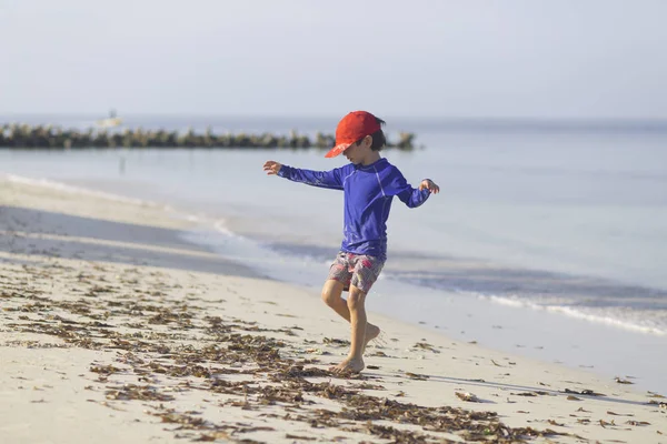 Glücklicher Junge spielt am Strand — Stockfoto