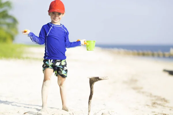 Menino feliz brincando na praia — Fotografia de Stock