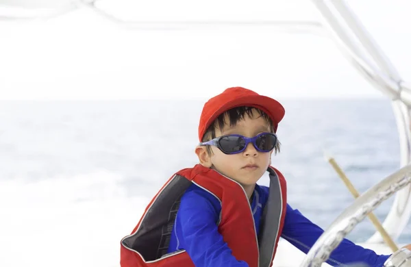 Niño feliz conduciendo un barco — Foto de Stock