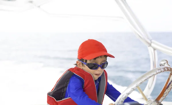Rapaz feliz dirigindo um barco — Fotografia de Stock
