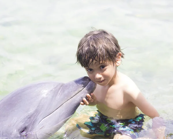 Estilo de vida de férias - Rapaz feliz abraçando um golfinho — Fotografia de Stock