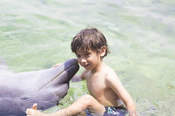 Urlaub Lebensstil -glücklicher Junge umarmt einen Delphin — Stockfoto