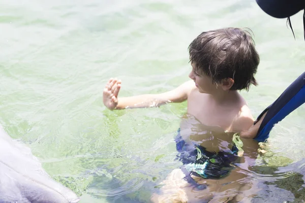 Urlaub Lebensstil -glücklicher Junge umarmt einen Delphin — Stockfoto