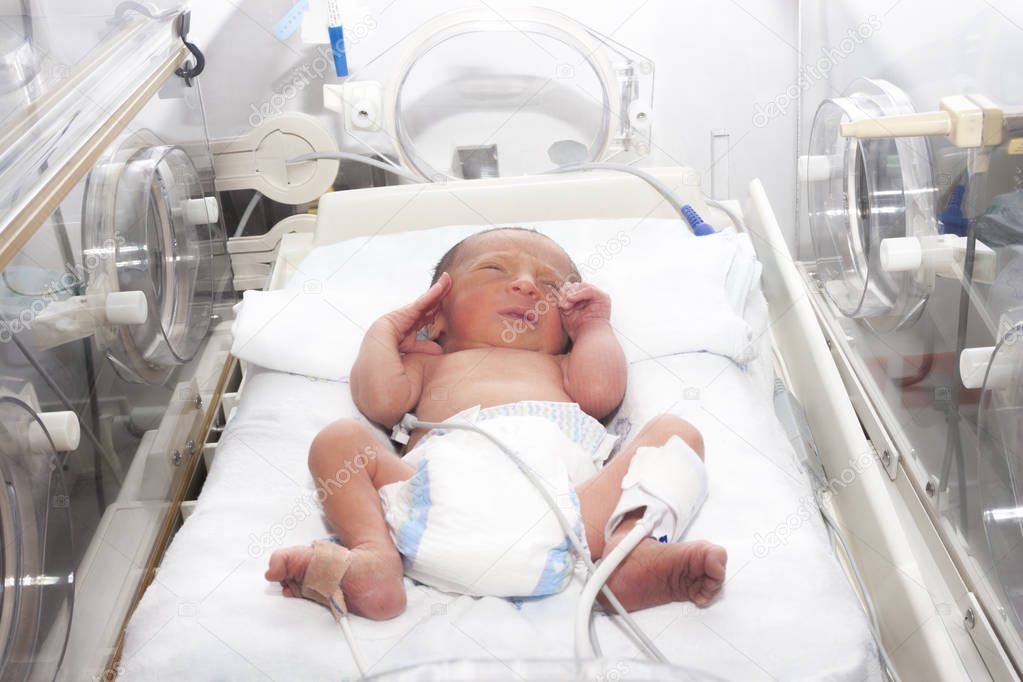 Newborn baby inside incubator