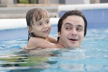 Mutlu baba ve kızı yüzme havuzunda