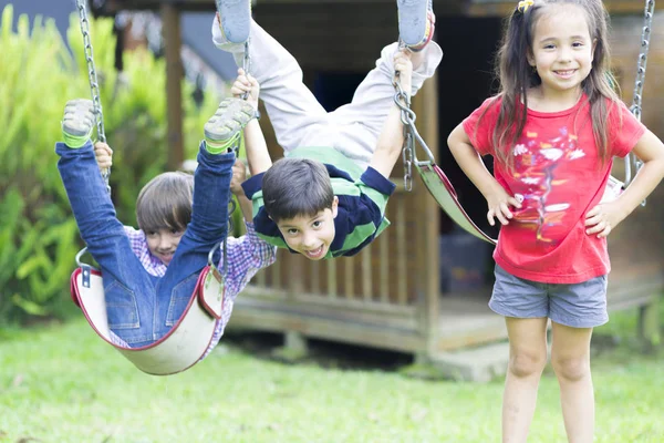 Happy children swinging — Stock Photo, Image
