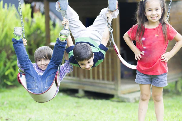 Happy children swinging — Stock Photo, Image