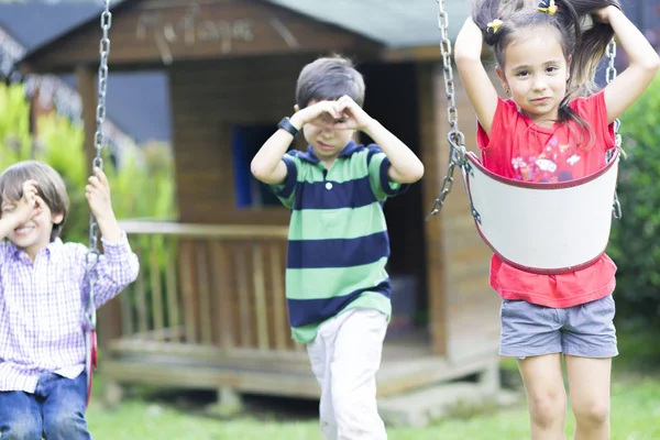 Happy children swinging — Stock Photo, Image