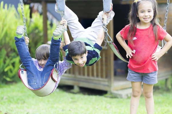 Happy children swinging — Stock Photo, Image