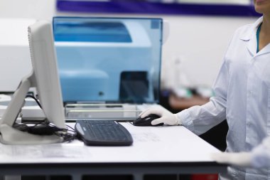 Laboratuvarda dizüstü bilgisayarda çalışan kadın hemşire.