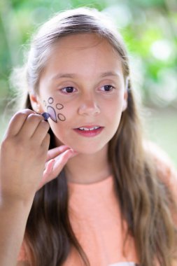 Güzel Genç Yüzünü boyatıyor, Makyaj yapıyor, Açık havada